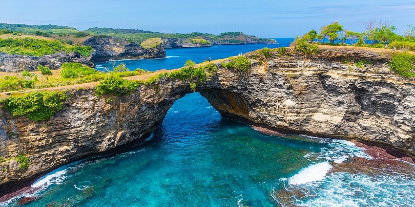 Broken Beach, places to visit in Nusa Penida, with a natural rock arch and turquoise water beneath.