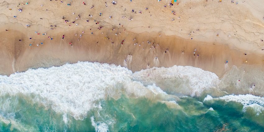 A glimpse of shimmering waters meeting the pristine golden sands decked with trees.