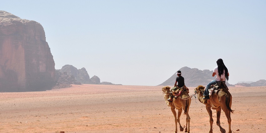 A group of tourists take camel rides in the Thar Desert for a unique experience.