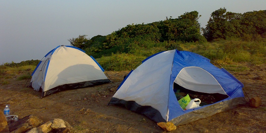 A picture of a campsite in Kanakapura with two tents amidst a rugged terrain