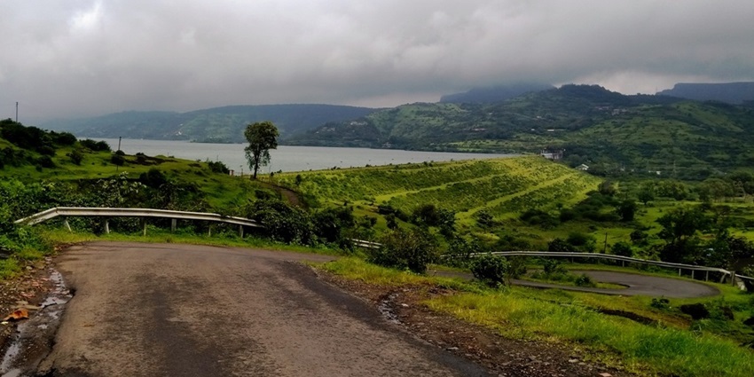 Stunning view of Pawna Dam with a tranquil lake and surrounding hills.