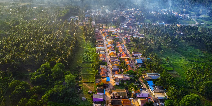 Koothagal village in Ramnagara with green fields, rocky hills, and scattered homes.