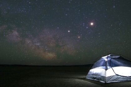 An image of people enjoying camping in Maharashtra amidst mountain ranges at night.