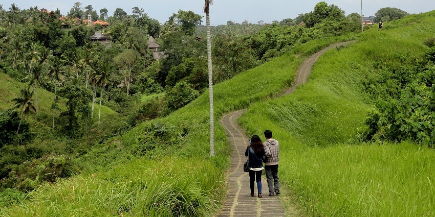 A couple walks on a trail on the Campuhan Ridge Walk at Sayan, one of the best places to visit in Ubud.