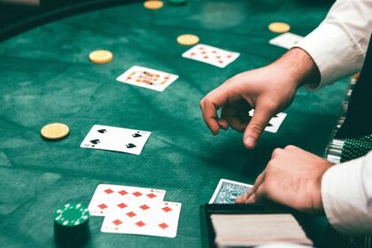 A glimpse of a person shuffling a deck of cards and displaying it on the green table.