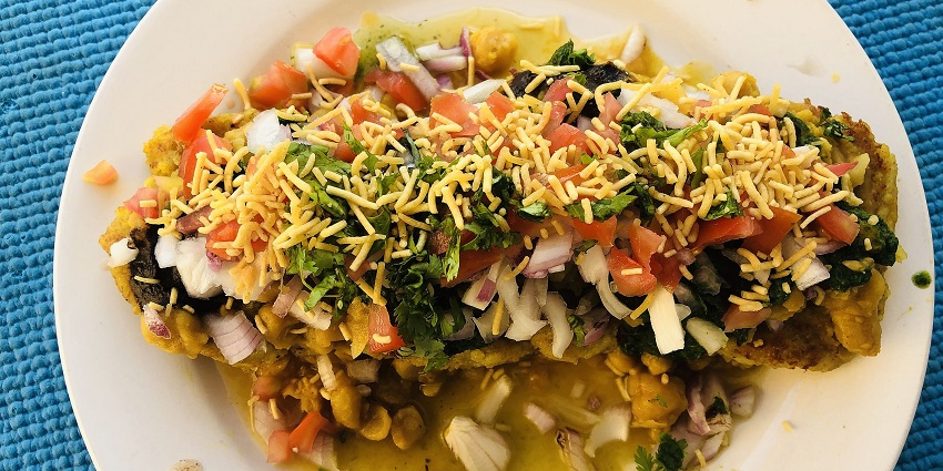Ragda patties with crispy potato patties topped with onions, tomatoes, peas and farsan