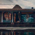 The reflection of a small Shiva temple can be seen on the waterbody in front of it