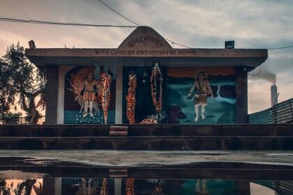 The reflection of a small Shiva temple can be seen on the waterbody in front of it