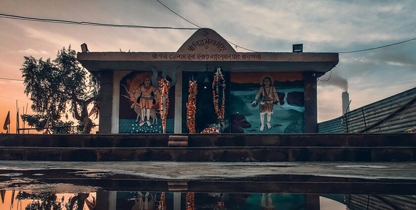 The reflection of a small Shiva temple can be seen on the waterbody in front of it