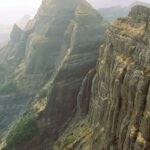 Chandragad Fort amidst Sahyadri mountains, showcasing ancient architecture and views.