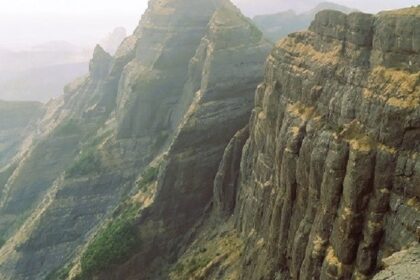 Chandragad Fort amidst Sahyadri mountains, showcasing ancient architecture and views.