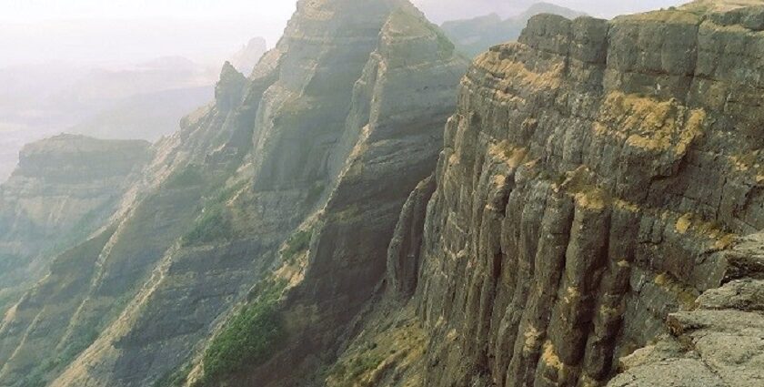 Chandragad Fort amidst Sahyadri mountains, showcasing ancient architecture and views.