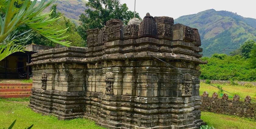 Image of Kukadeshwar Temple at Chavand with scattered stone structures and walls.