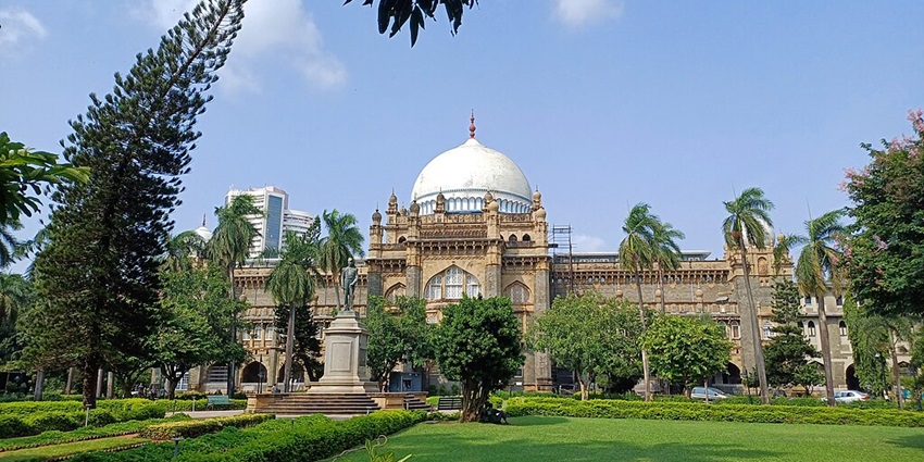 Image of the front view of CSMVS museum, showcasing its grand architecture and lush garden.