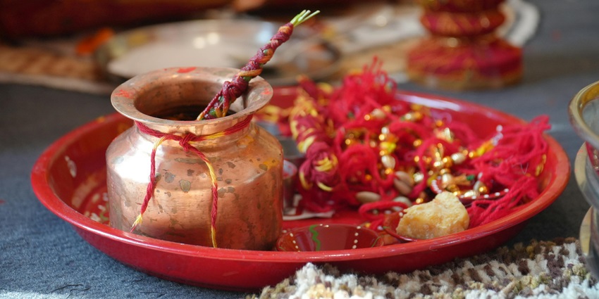 Image if a pooja thali decorated with hindu ritual essential on a golden coloured plate