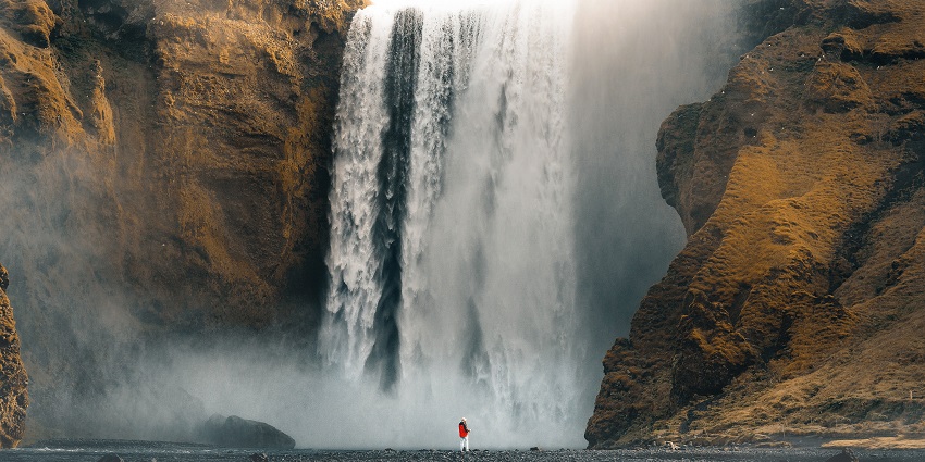 A glimpse of frothy waters pouring down from a height and hitting the lush grounds.