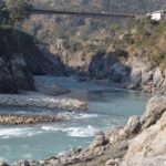 A picture of a hot spring surrounded by mountains and greenery