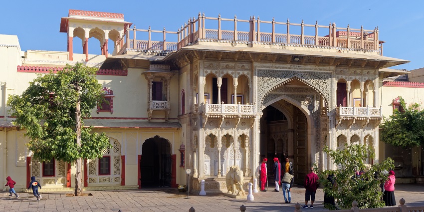City Palace in Jaipur features ornate architecture and vibrant colours with tourists.