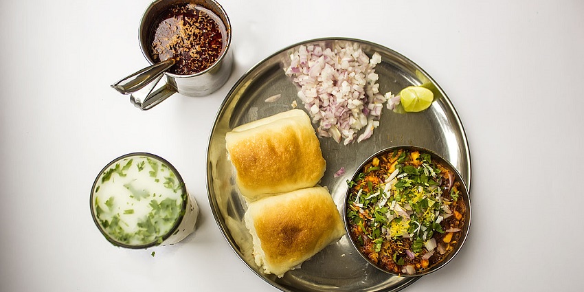 Misal Pav, a Maharashtrian delicacy served with cut onions, lemon wedge, and buttermilk.