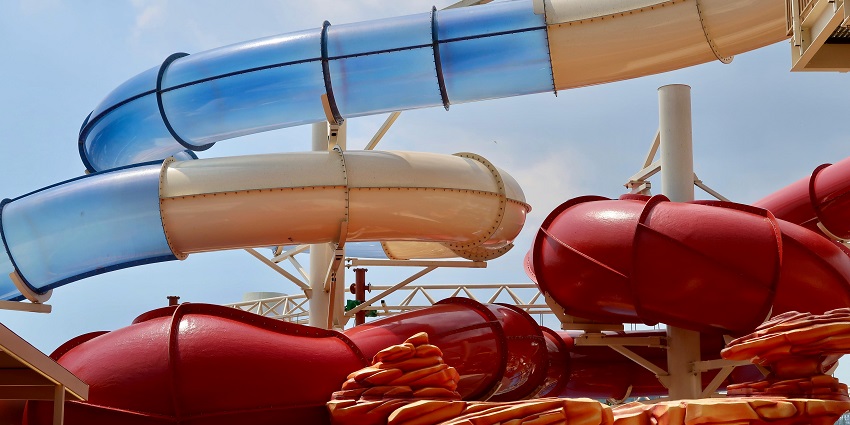 D Atlantis Aqua Park And Resort is a colourful playground with bright red and blue slides surrounded by greenery.
