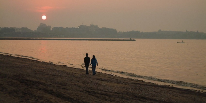 People enjoying at Dadar Chowpatty beach in Mumbai during sunset.