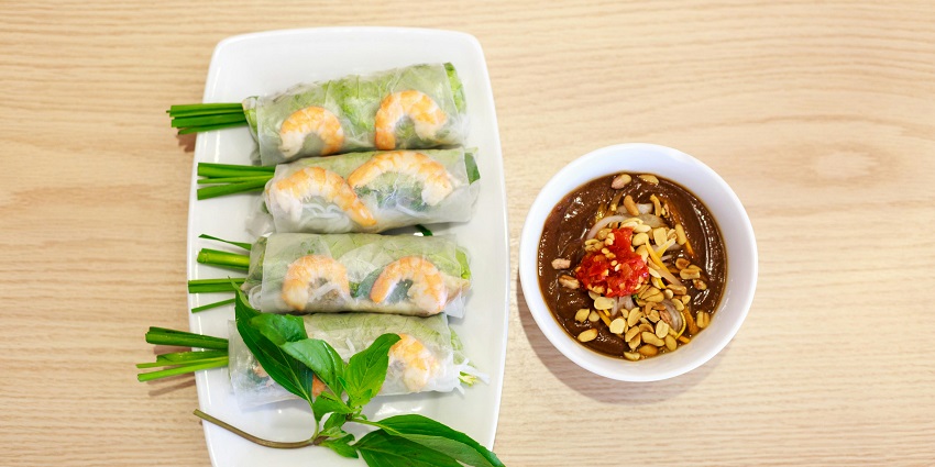 Khandavi topped with grated coconut and curry leaves served with a crisp and a dip.