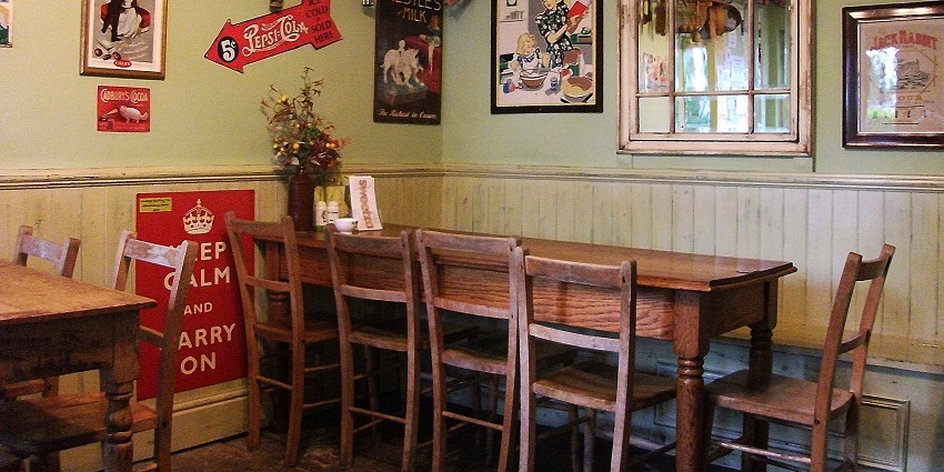 The inside of a beautiful café with wooden interiors and furniture and a cosy environment.