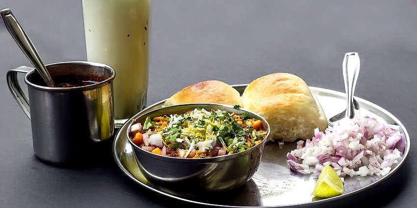 Fiery red Kolhapuri misal made with sprouted pulses, topped with farsan served with pav