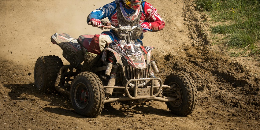Adventurous person riding an ATV quad bike, enjoying an exciting outdoor thrill.
