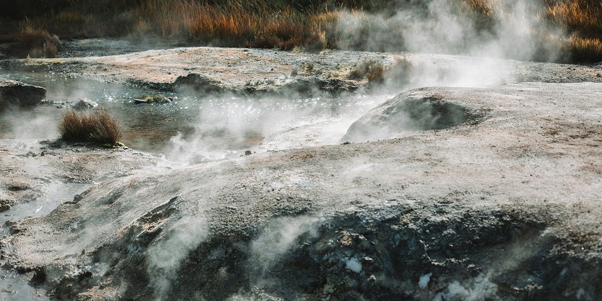 View of steaming hot spring amidst the rugged rocky landscapes