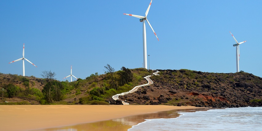 Majestic windmills standing tall against the scenic backdrop of Devgad Beach.