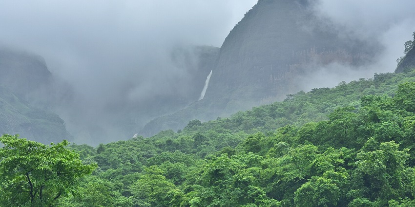 A serene view of the Western Ghats with a tranquil waterfall cascading down