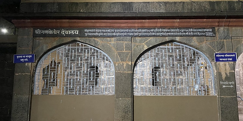A frontal view of the entrance of a historical Ganesha temple in Satara with traditional stone walls