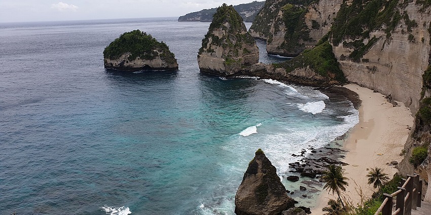 Diamond Beach, places to visit in Nusa Penida ,with white sand, small towering cliffs, and calm waves.