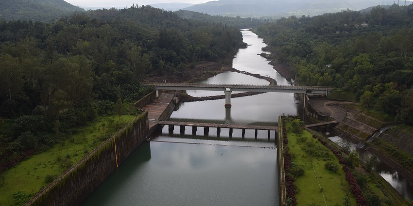 Magnificent dam with reflected water and mountains all around it for travellers.