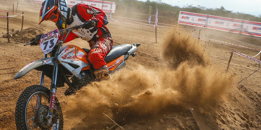 View of a man on a motocross bike enjoying dirt biking in Mumbai on a rugged trail.