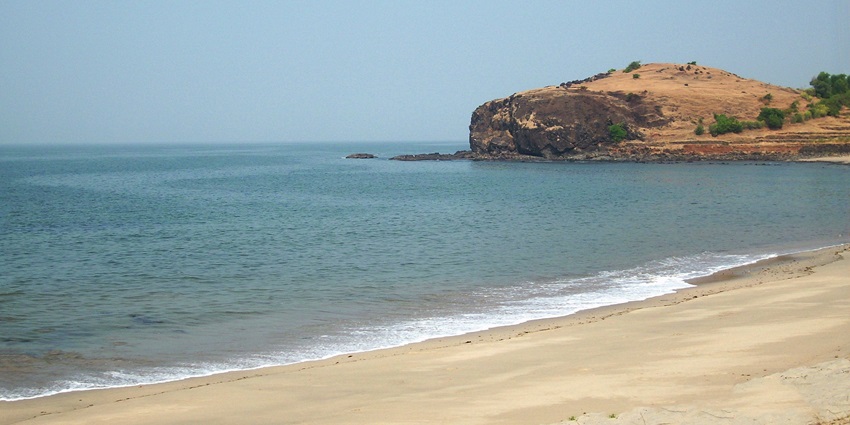 Image of Diveagar beach view with white sand and a big rock on the side of the beach
