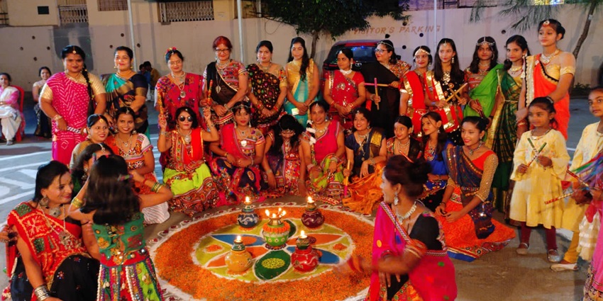 An image of a team of women in traditional attire getting ready to play dandiya