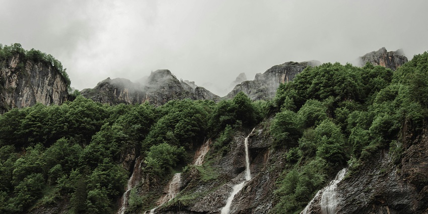 A beautiful image of Dodhani waterfalls surrounded by dense greenery and rocks.