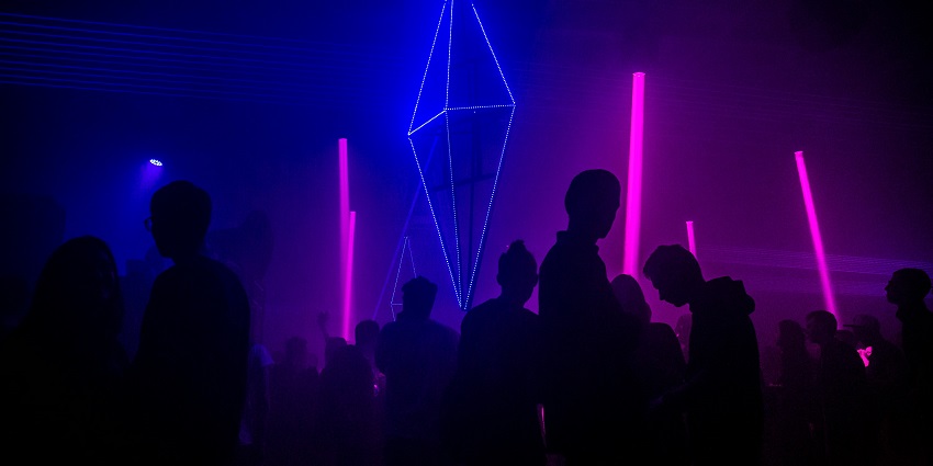 Image of DJ event at Dragon Lounge, Pondicherry with colourful lights and people dancing