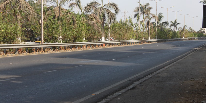 View of the Palm Beach Road in Mumbai with trees and modern buildings in the background.