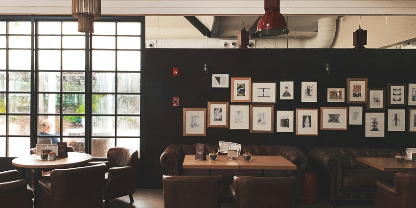 Image of a cafe with elegant decorations and sitting arrangement with wall posters
