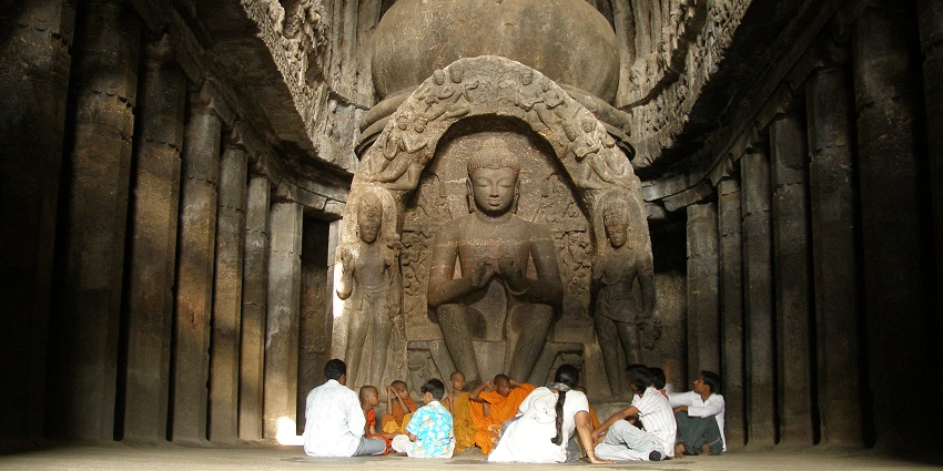 A religious meeting inside an ancient Buddhist cave temple at Ajanta and Ellora Caves.