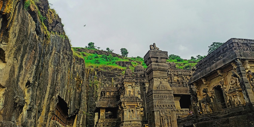 Image of a a group of stone structures with a green hill in the background