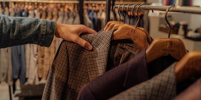 Person in Black and Brown Plaid Long Sleeve Shirt Holding Brown Coat - shopping malls in Jalandhar