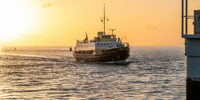 Enjoy a picturesque sailing trip as people cruise into the sunset on a serene evening