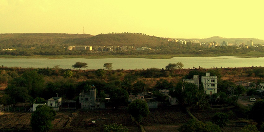 A pleasant view of Pashan Lake, surrounded by lush greenery and trees.
