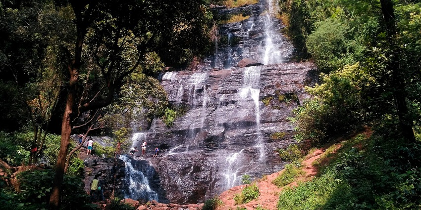 Jhari Falls feature cascading waterfalls surrounded by lush greenery and tranquility.