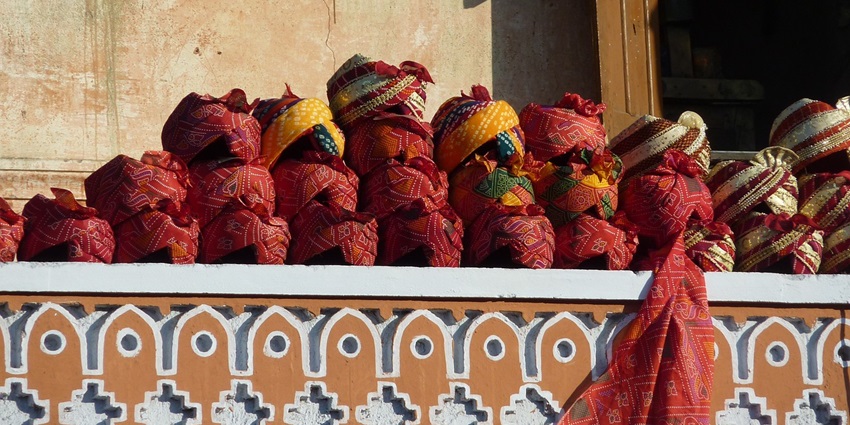 Street vendor selling packing snacks at a stall in a busy bazaar in Jaipur.
