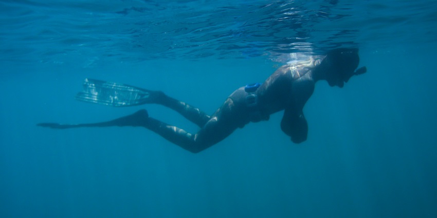 An image of visitors swimming and snorkelling in the clear waters of Melasti Beach.